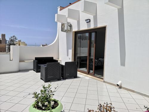 加利波利B&b tra scirocco e tramontana的白色的建筑,设有黑家具的庭院