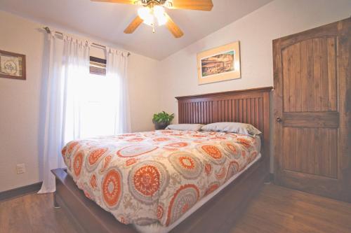 MancosSunny Southwest Cottage的一间卧室配有一张带床罩的床和窗户