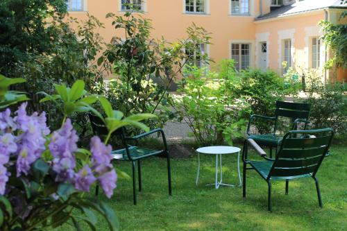 拉弗雷切Hôtel Le Gentleman的花园里的一组椅子和一张桌子