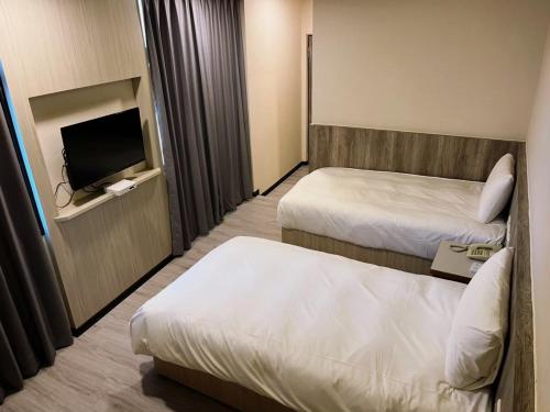 金城新金门商旅的酒店客房设有两张床和一台平面电视。