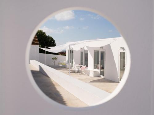 阿托吉亚达巴莱亚CASASUPERTUBOS® Villa 9 & Apart 1-8的透过圆形窗户可欣赏到白色房子的景色