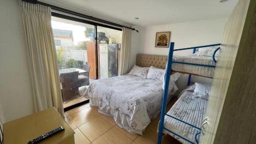 拉塞雷纳Calor De Hogar La Serena的一间带两张双层床的卧室和一个阳台