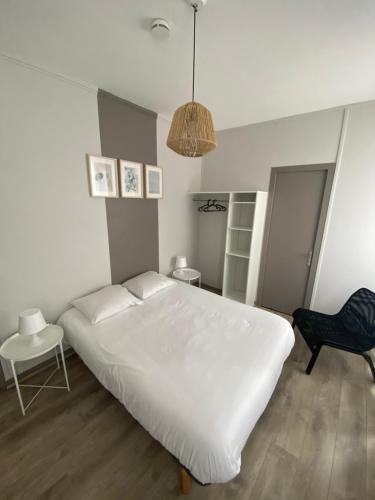 多勒Le Relais de la Gare的卧室配有一张白色大床和一把椅子