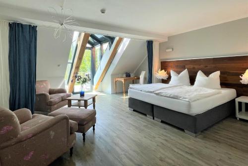 梅伦新梅伦廷水上城堡酒店的一间卧室配有一张床、一把椅子和一张沙发