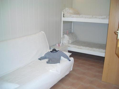 莱斯卡拉L' Escala centre la Platja的一间设有白色沙发和两张双层床的客房