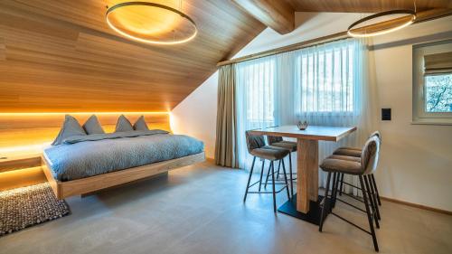 萨斯费Boutique Hotel La Gorge的一间卧室配有一张床和一张桌子及凳子