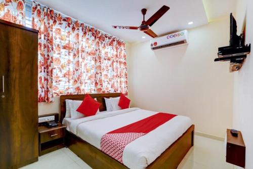 拉杰果德Hotel Blue Leaf的一间卧室配有一张带红色枕头的床和一扇窗户