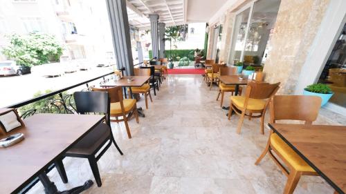 安塔利亚My Home Hotel Gulluk的餐厅设有桌椅和窗户。