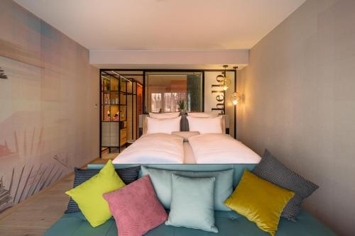 蒂门多弗施特兰德The Flamingo的一间卧室配有一张带色彩缤纷枕头的大床