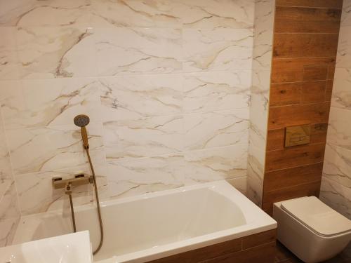 苏瓦乌基Apartament Korczaka Centrum的浴室配有白色浴缸和卫生间。