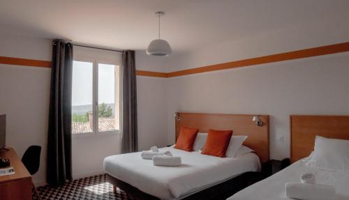 鲁西永La Maison des Ocres - Provence的酒店客房设有两张床和窗户。