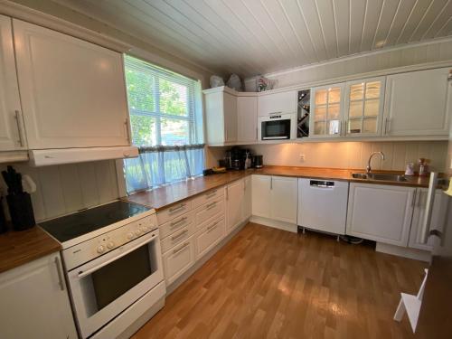 尤坎Sentral tomannsbolig ved park, Rjukan的厨房铺有木地板,配有白色橱柜。