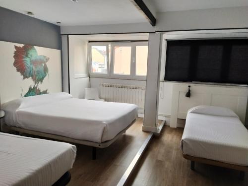 拉科鲁尼亚玛拉旅馆的一间卧室设有两张床和窗户。