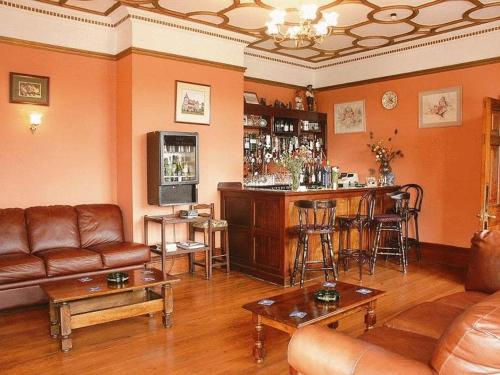 金斯林葛兰奇酒店的客厅设有酒吧、沙发和椅子