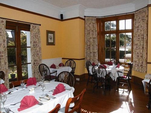 金斯林葛兰奇酒店的餐厅设有白色的桌椅和窗户。