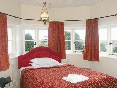 金斯林葛兰奇酒店的一间卧室配有红色的床和2条毛巾