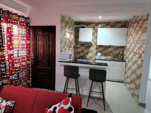 罗安达28A, Apt#13 Lumir Apartamentos. Encantador Parque Incl.的一间厨房,里面配有红色的沙发和两张凳子