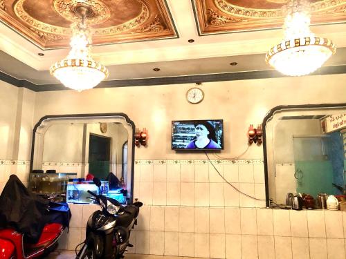 胡志明市Khách Sạn Hồng Hà 2的一间设有摩托车、镜子和时钟的房间