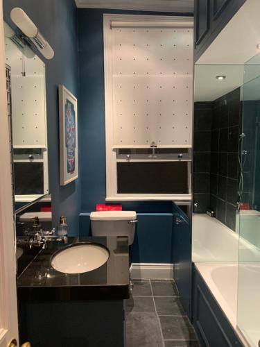 伦敦Charming and full of character的浴室配有卫生间、盥洗盆和浴缸。