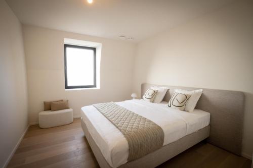 卡德赞德La Risacca, Luxurious, 3 bedroom, sea view design apartment的白色卧室设有一张大床和窗户