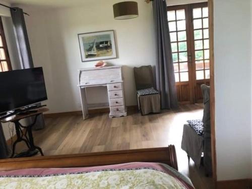 Saint-Étienne-la-Thillaye梅非庄园住宿加早餐旅馆的一间卧室配有一张床、一张书桌和一台电视