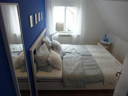 海利根达姆Kleine Sandburg Heiligendamm的一间卧室配有一张蓝色墙壁的床
