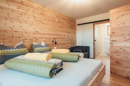 霍赫林德Hiasl Zirbenhütte的一间卧室设有两张床和木墙