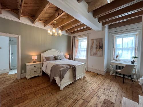 NeuvilleLa Demeure du Capitaine的一间卧室配有一张床和一个吊灯