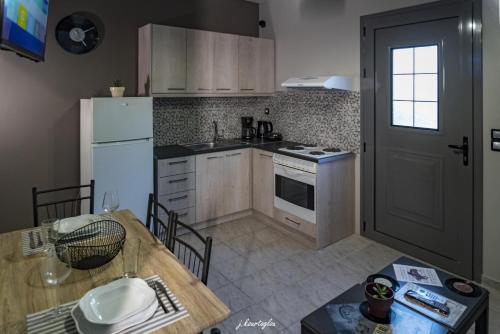 新基奥斯Music Reflections Apartment near Nafplio的厨房配有桌子和白色冰箱。