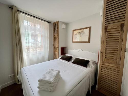 昂蒂布Les Petits Volets 2的卧室设有一张白色大床和一扇窗户。