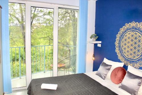 切尔诺莫雷茨SUNSET ART Beach Front的一间带蓝色墙壁和一张床的卧室以及一个阳台