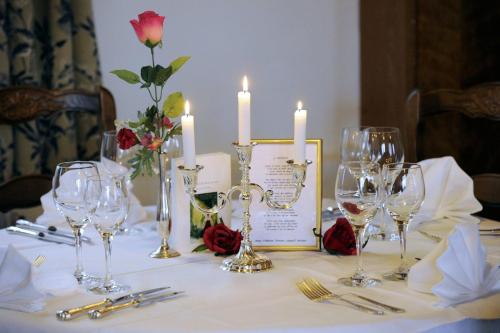 穆尔巴赫Hotel-Spa & Restaurant Logis Domaine Langmatt的一张桌子,上面放着酒杯和蜡烛