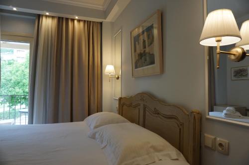 约阿尼纳阿尼莫利亚温泉度假酒店 的一间卧室配有一张床、镜子和窗户