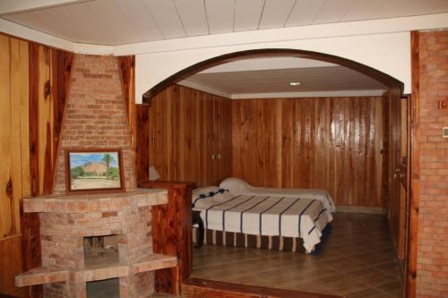 廷吉尔AZIGHAME Complexe Touristique的一间带壁炉的卧室和一张位于客房内的床