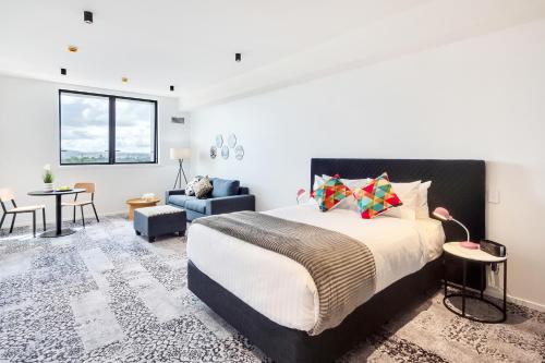 奥克兰Roomie Apartment Hotel的一间卧室设有一张床和一间客厅。