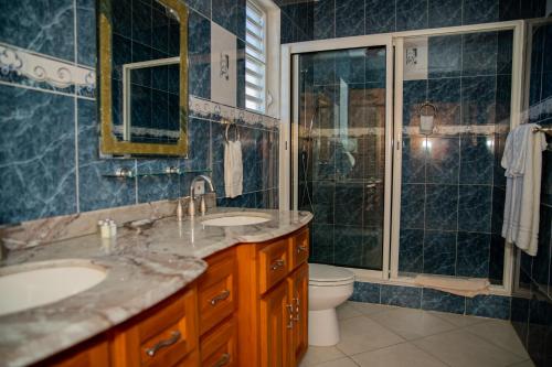 Sandy Ground Village逸角别墅酒店的一间带两个盥洗盆、淋浴和卫生间的浴室