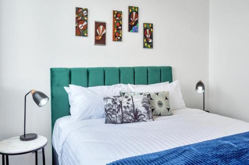 奥克兰Roomie Apartment Hotel的一间卧室配有一张带绿色床头板的床