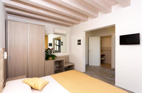 佩莱斯特里纳斯特拉维多宾馆的一间卧室配有一张床,墙上配有电视