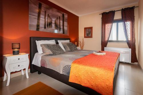 波尔蒂芒THE PENTHOUSE IN AMARILIS的一间卧室配有一张橙色墙壁的床