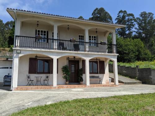 卡瓦尼亚斯Casa Cabanas的白色的房子,上面设有阳台