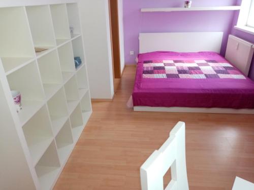 莫斯特Apartment ODEON的一间卧室配有一张紫色的床,铺有木地板