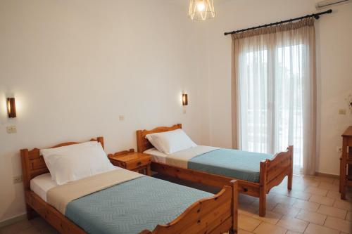 阿里拉斯Pagonia Apartments的带窗户的客房内的两张床