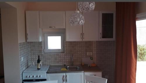 蒂瓦特Apartmani Tanja的厨房配有炉灶、水槽和窗户。