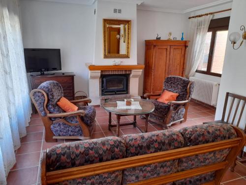 埃尔阿雷纳尔La casa del puerto的客厅配有沙发、椅子和壁炉