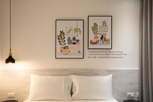 台中市乐微行旅的卧室,床上方有两张植物图片