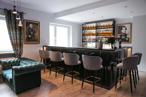 库罗阿尔滕堡Hotel Waldeslust的酒吧配有绿色的沙发和椅子