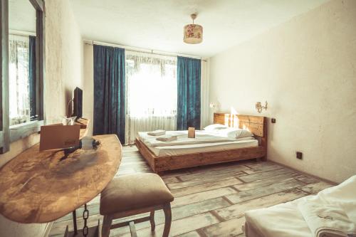 RakovoDaulite boutique hotel的一间卧室配有桌子、床和窗户