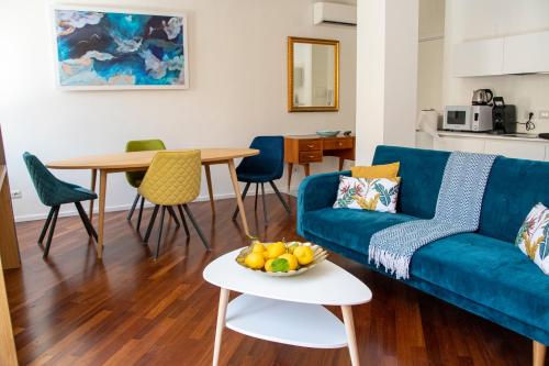 陶尔米纳Castalia Apartments & Rooms Duomo Taormina的客厅配有蓝色的沙发和桌子