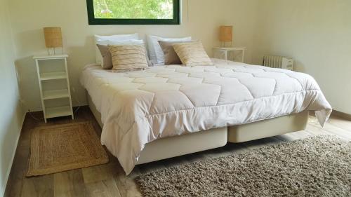 普拉亚德米拉Casa da Mata的卧室配有一张大白色的床和地毯