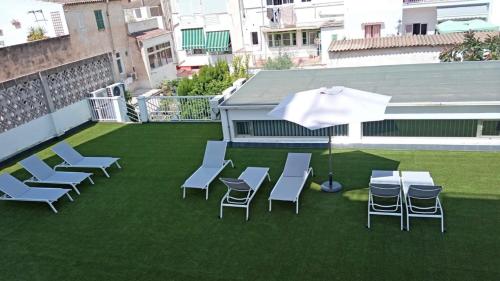 马略卡岛帕尔马阿卜雷酒店的草地上带椅子和遮阳伞的天井